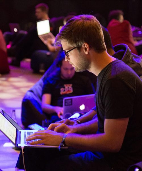 a man sitting in front of a laptop